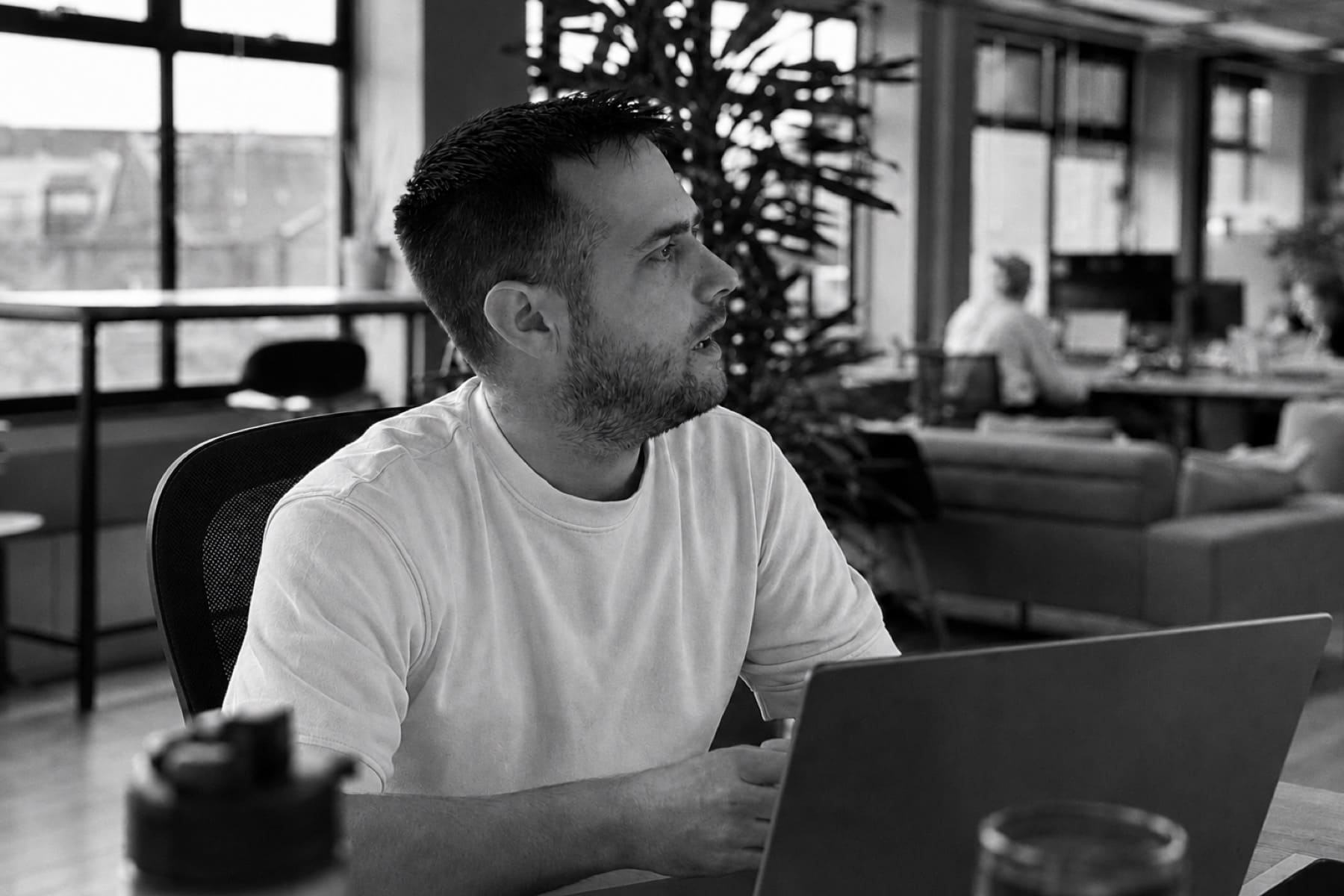Working at a laptop in an open-plan office.