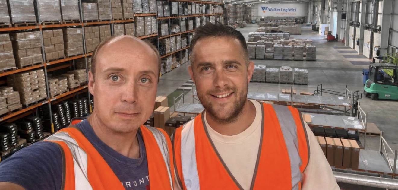 Two people in hi-vis vests on a mezzanine above the pick faces and loading bays at Walker Logistics&rsquo; Membury warehouse.
